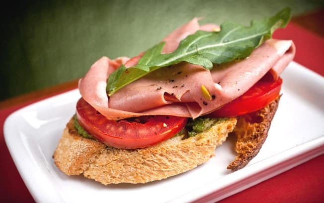 Bruschetta de mortadela com pesto de rúcula